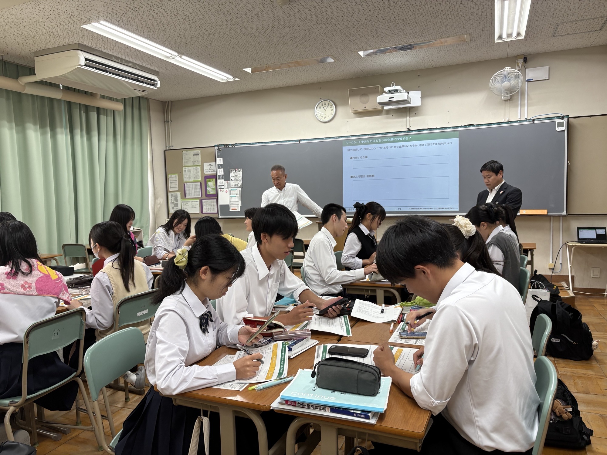 どちらの企業に投資をするのか生徒たちがグループワークをしている写真