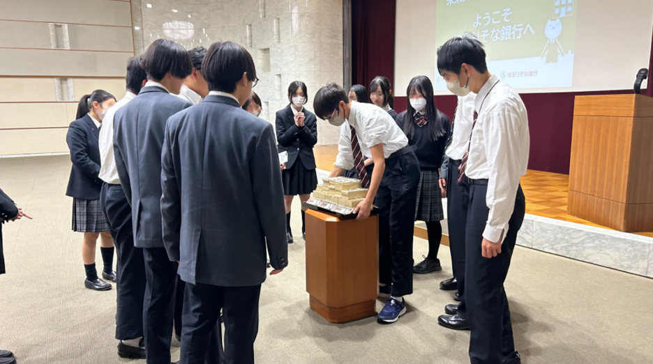 生徒が1億円の重さを体験している写真